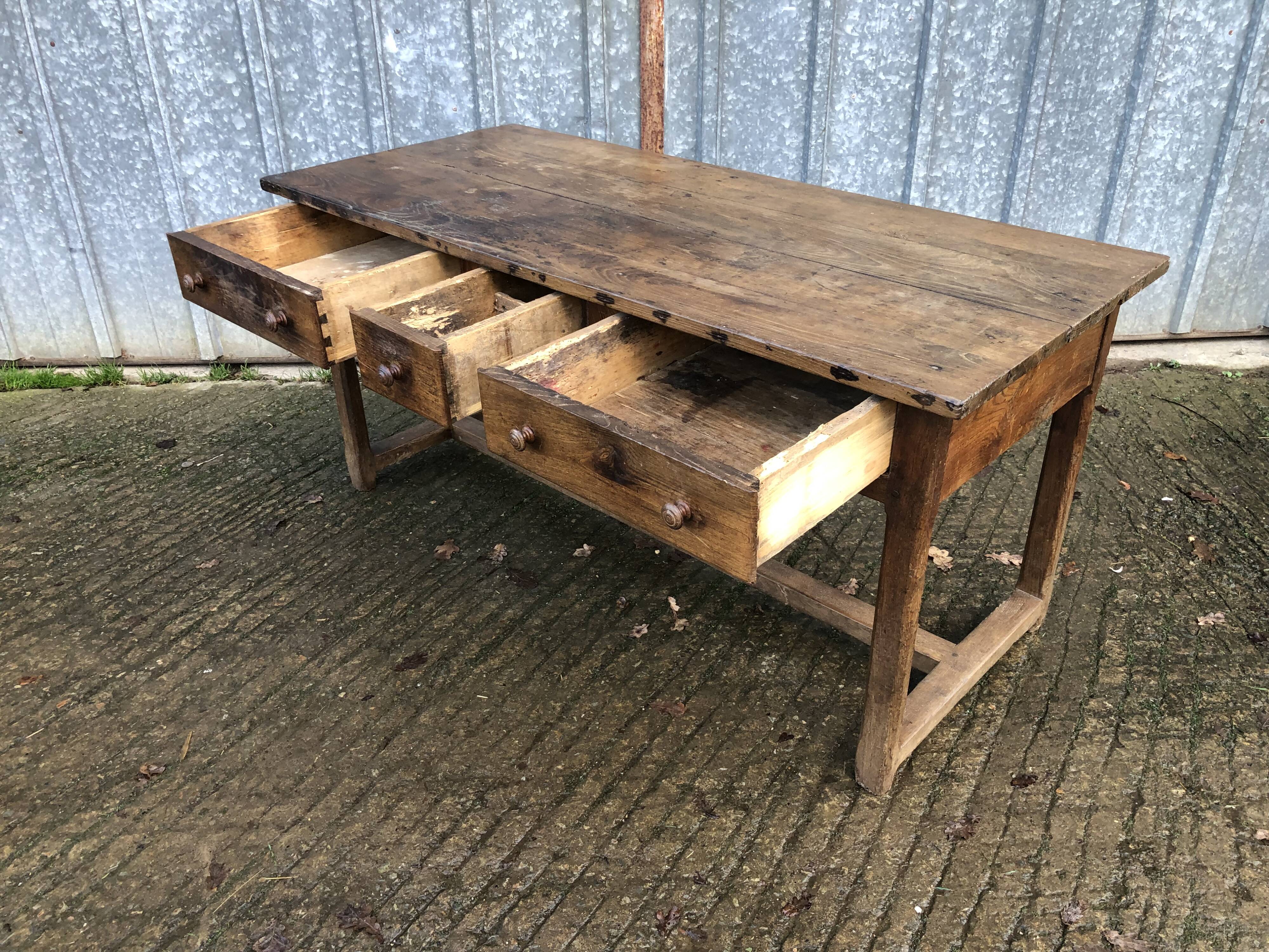 Old chestnut table with 3 front drawers and a cat bar.