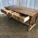 Old chestnut table with 3 front drawers and a cat bar.