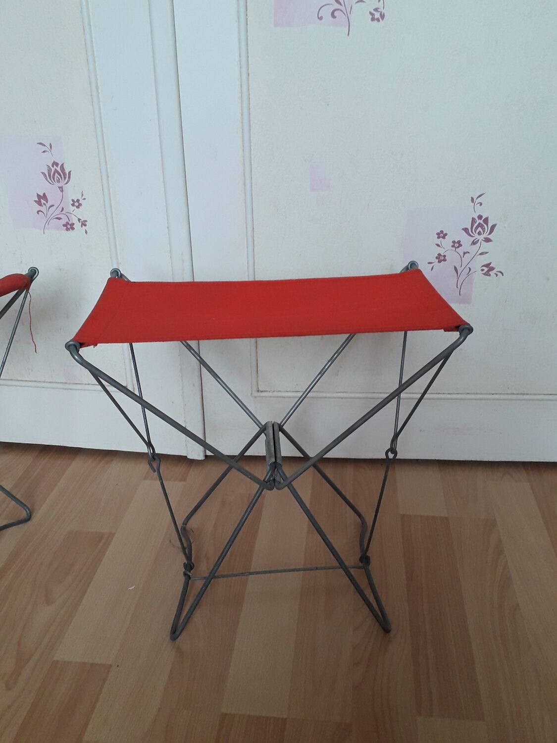 Folding stool in red canvas but unstitched on one side