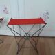 Folding stool in red canvas but unstitched on one side