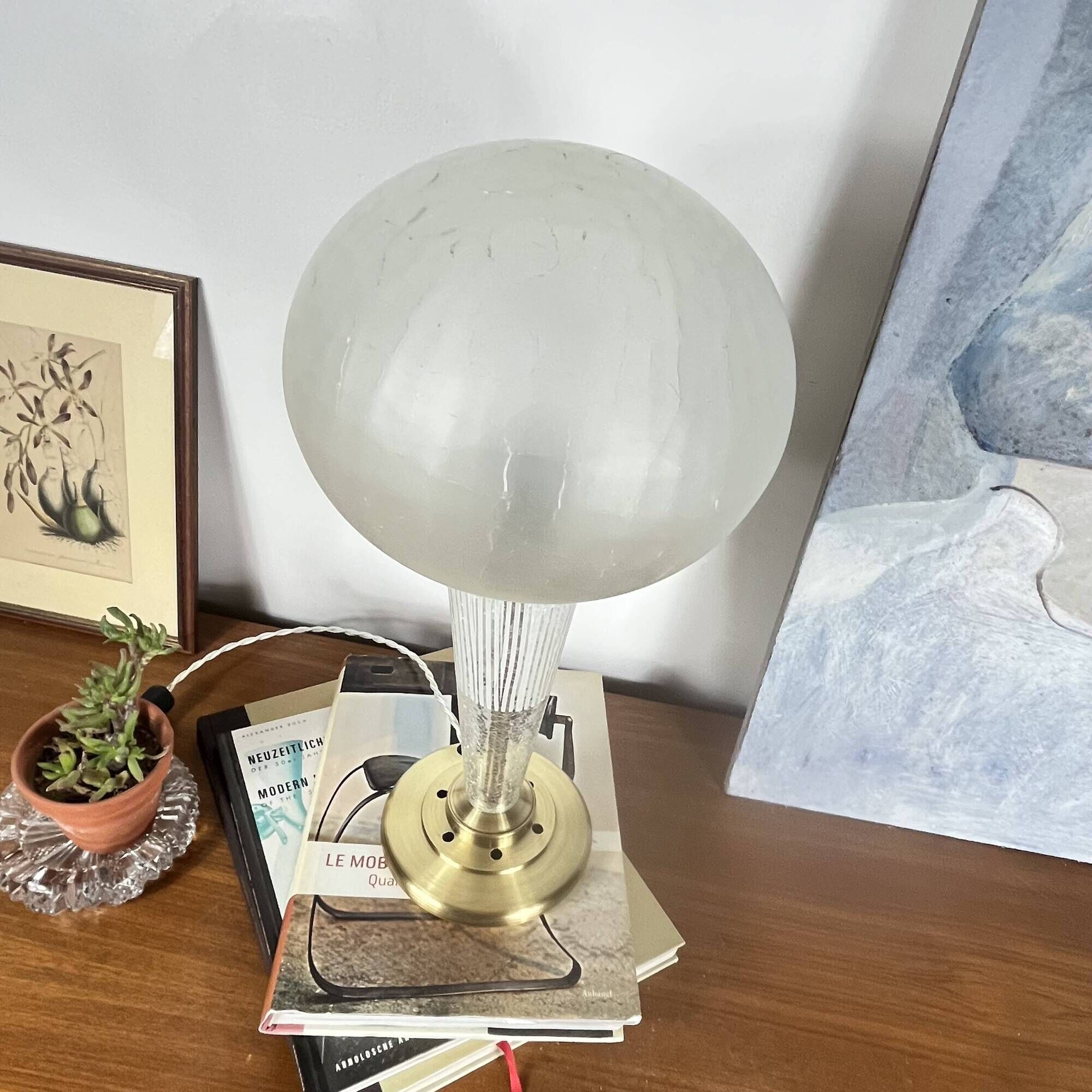 Large globe table lamp with a cracked glass base and brass stand.