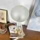 Large globe table lamp with a cracked glass base and brass stand.