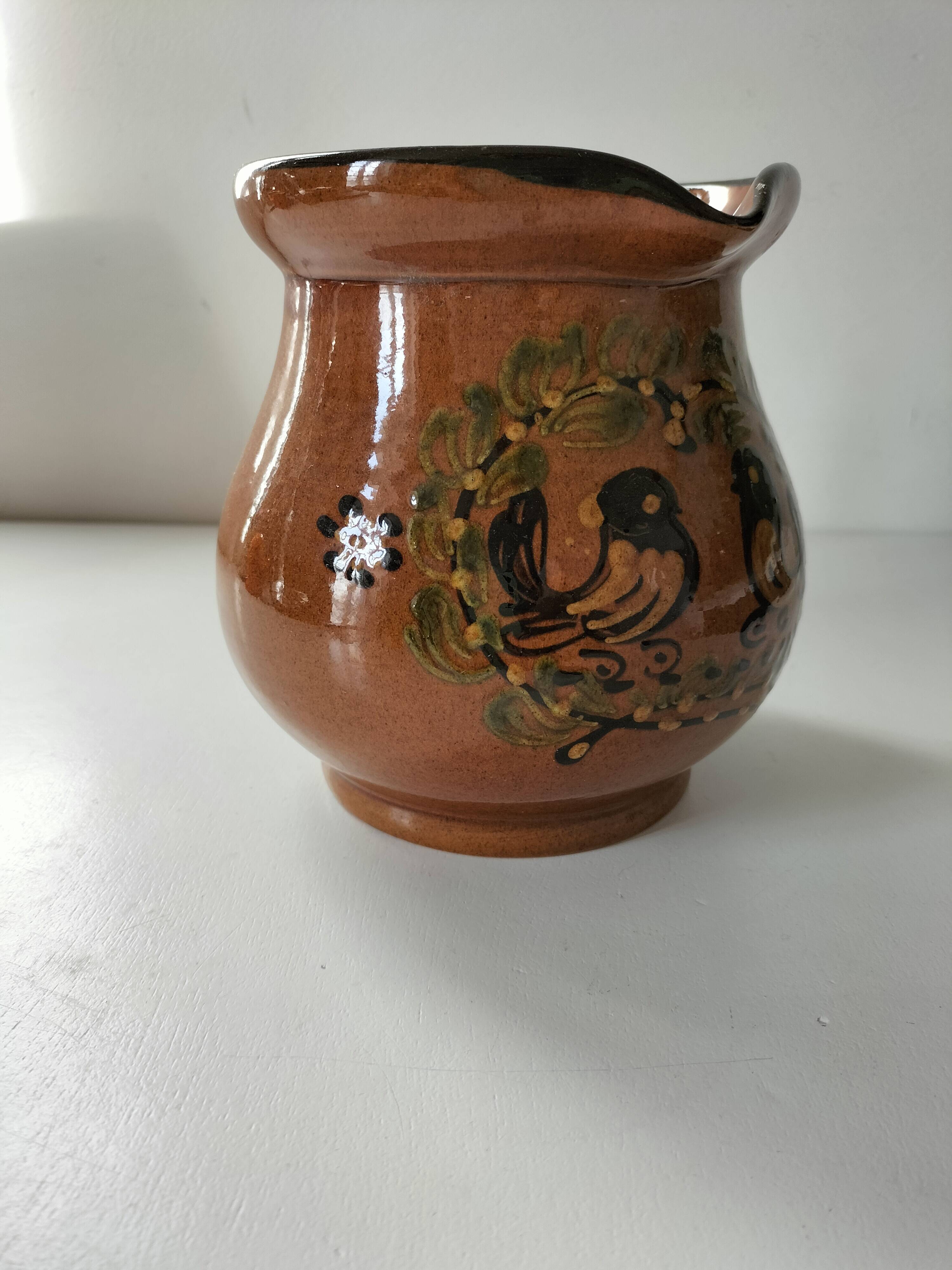 Glazed earthenware pitcher signed HR with a design of stylised birds.