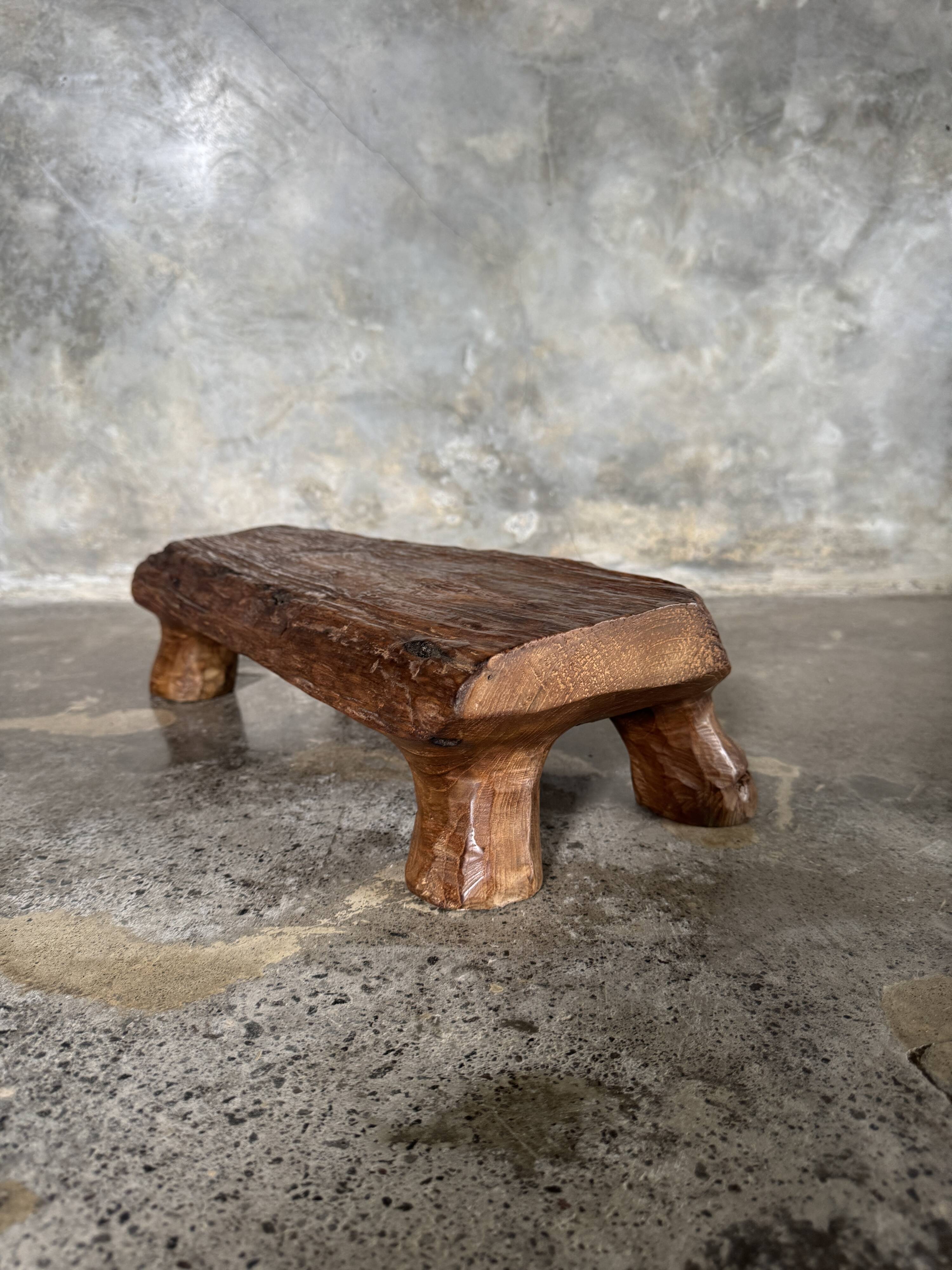 Small stool, footrest in blond teak, organic monoxyle with cut corners.