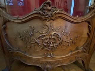 Large wooden display cabinet in Louis XV/rococo style with a strongly curved front.