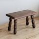 Vintage rectangular stool in dark wood with turned legs.
