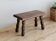 Vintage rectangular stool in dark wood with turned legs.