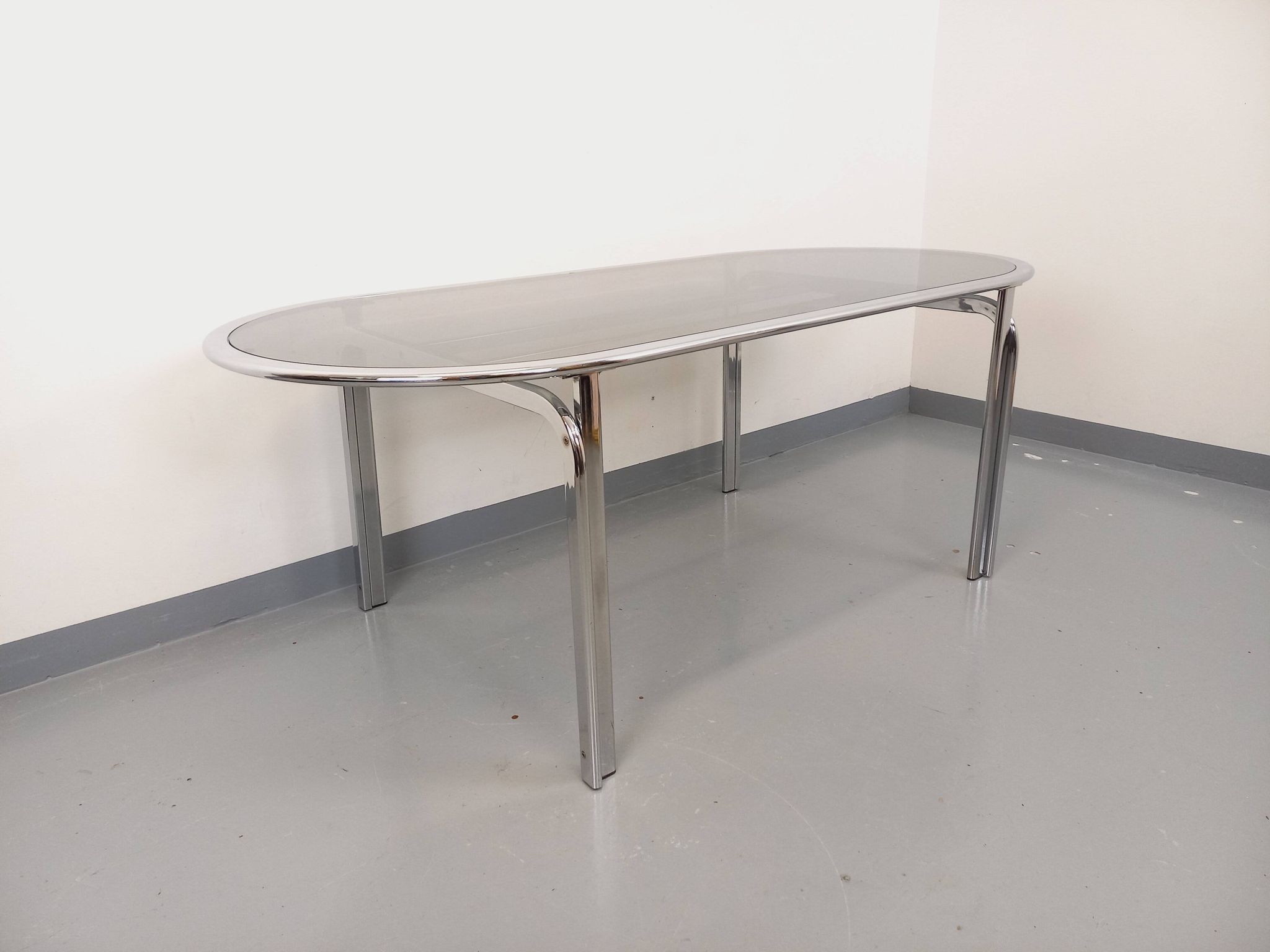 Vintage oval dining table in smoked glass and chrome metal, Space Age style.