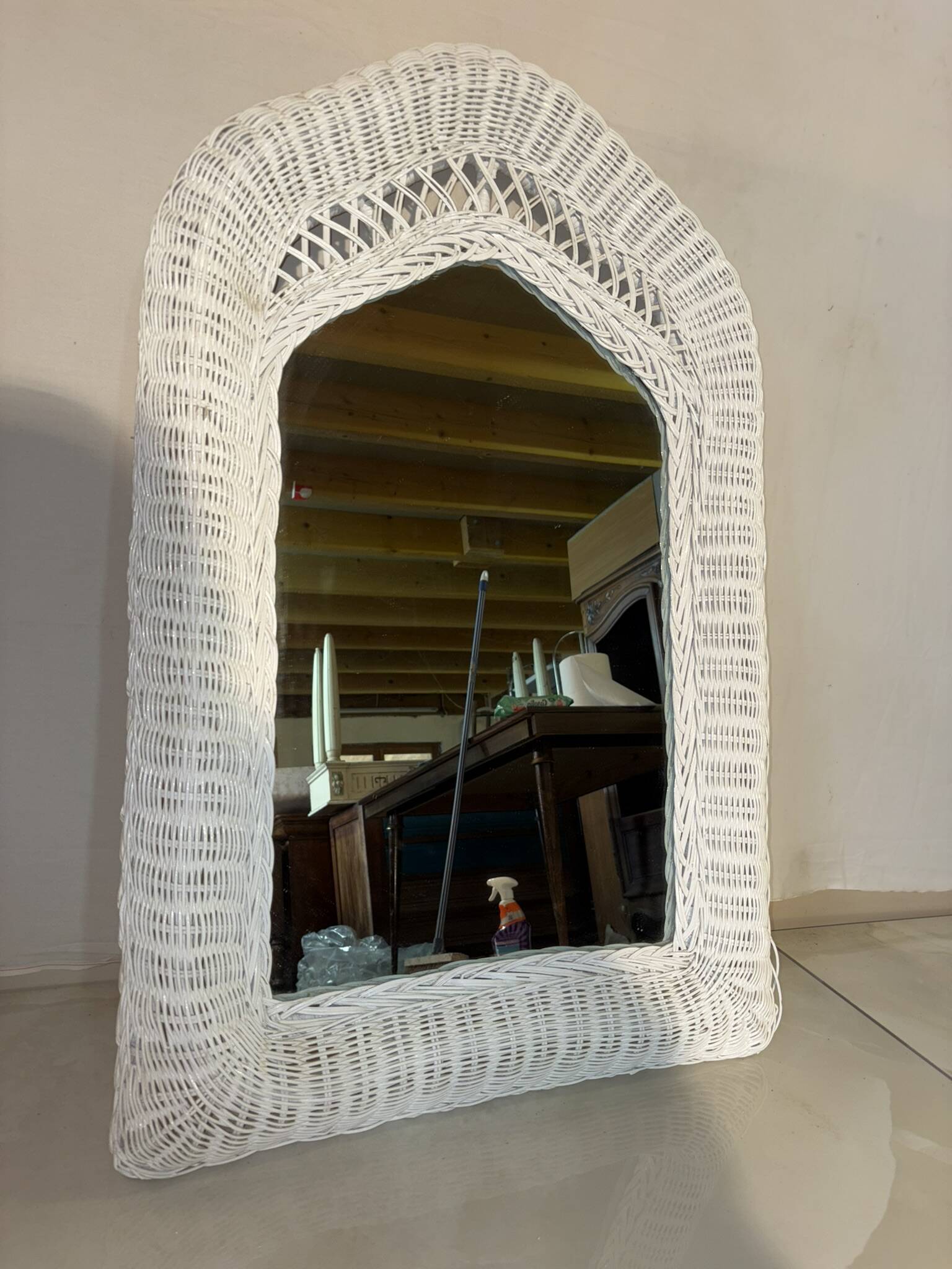 Vintage white rattan mirror with a gothic frame.