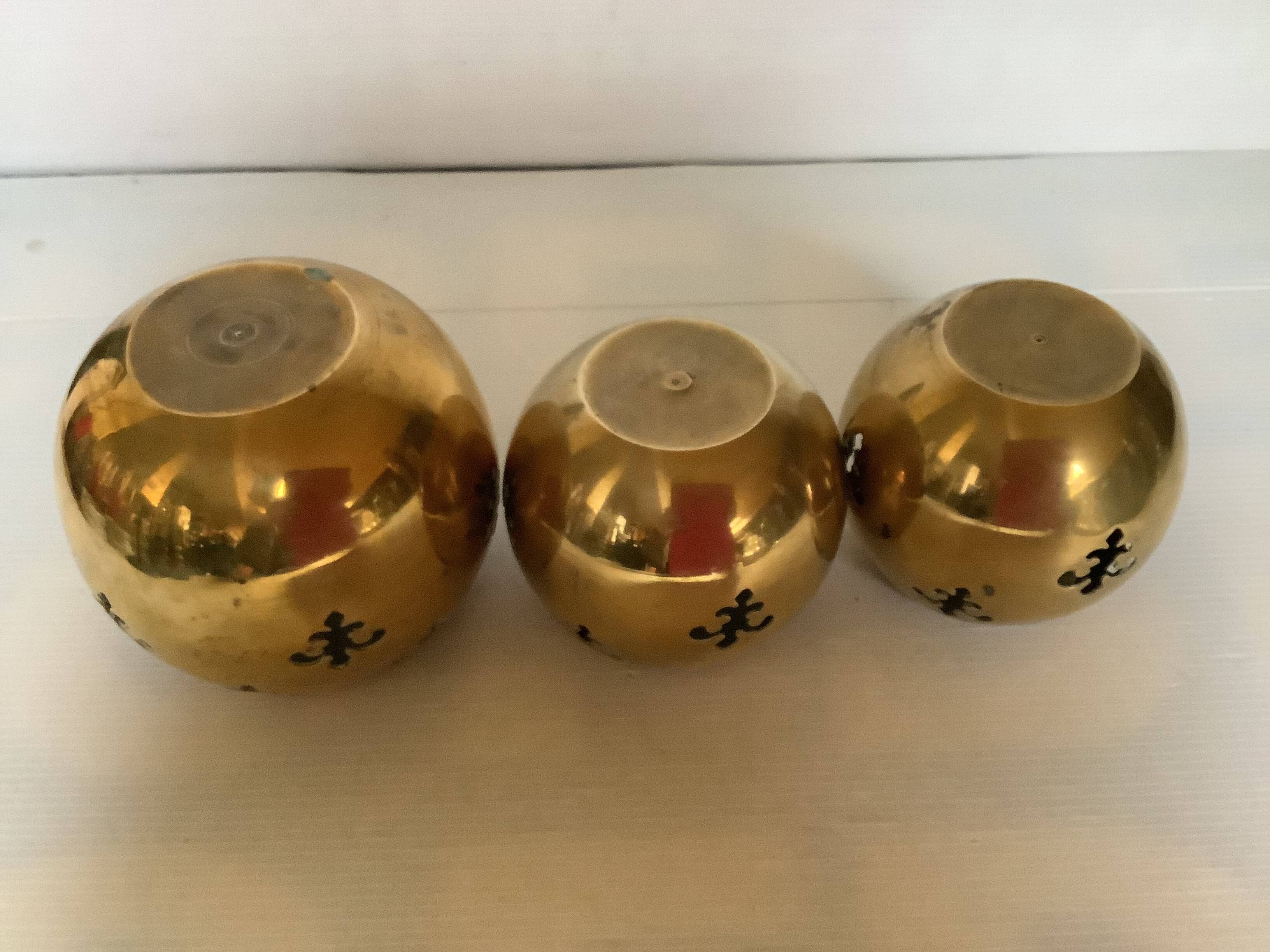 Trio of brass fleur-de-lis candle holders