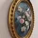 Cadre ovale en verre bombé et décor de fleurs