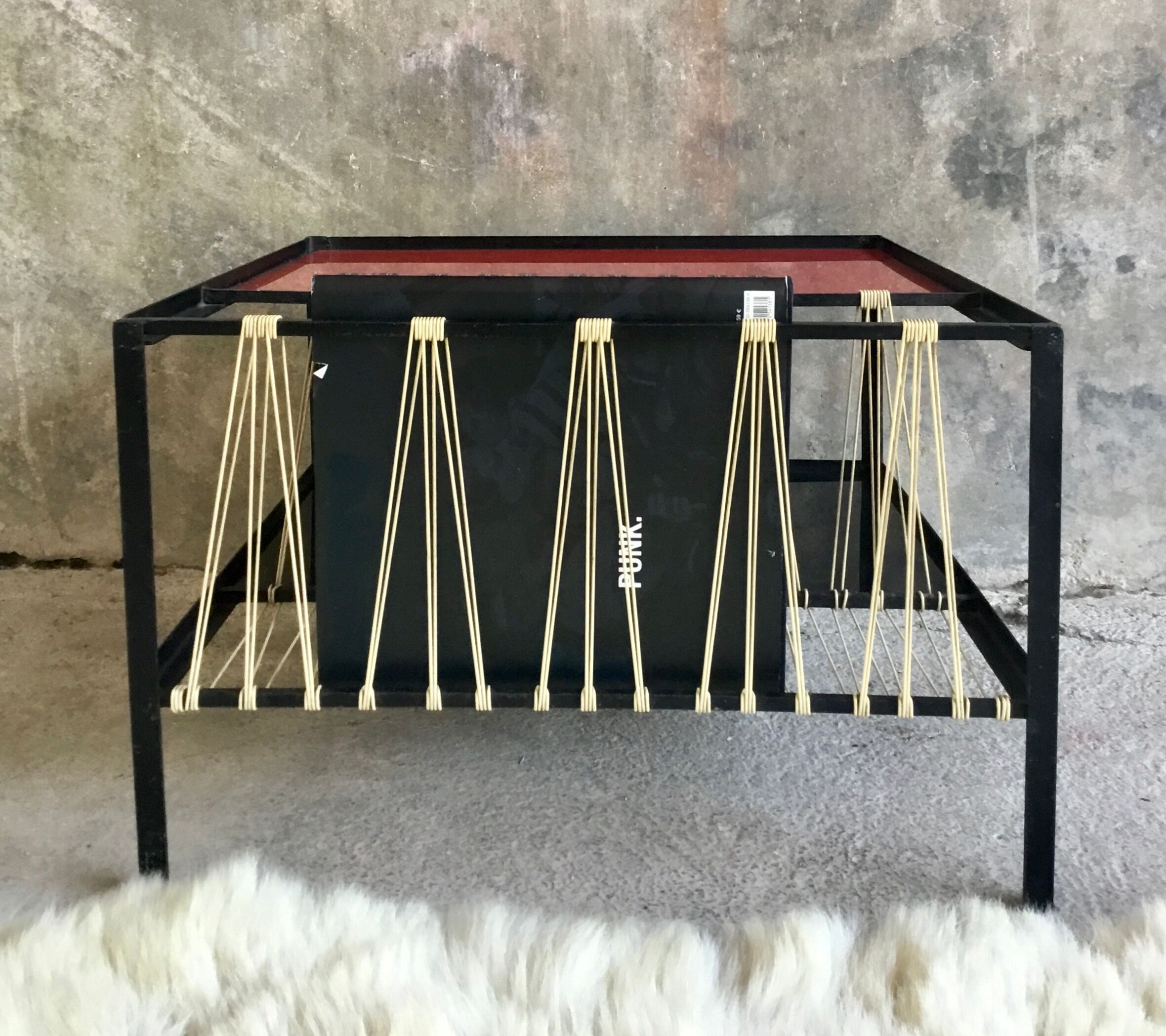 Modernist metal coffee table with a magazine rack in 1950s design.