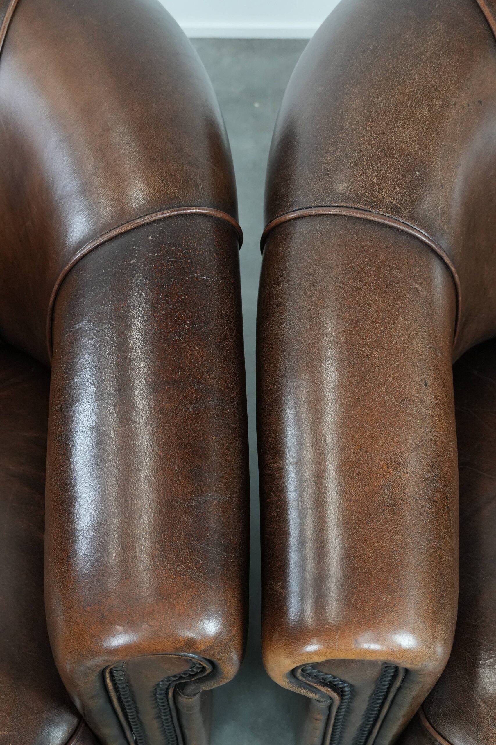 Set of two sheepskin club armchairs with fixed seat cushions