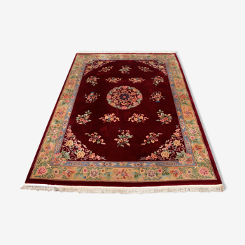 China wool fringed rug with floral pattern on deep plum background 393x274cm