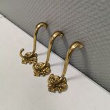 Three old and beautiful brass hooks with decorative motifs