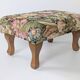 Large vintage upholstered footstool with curved legs.