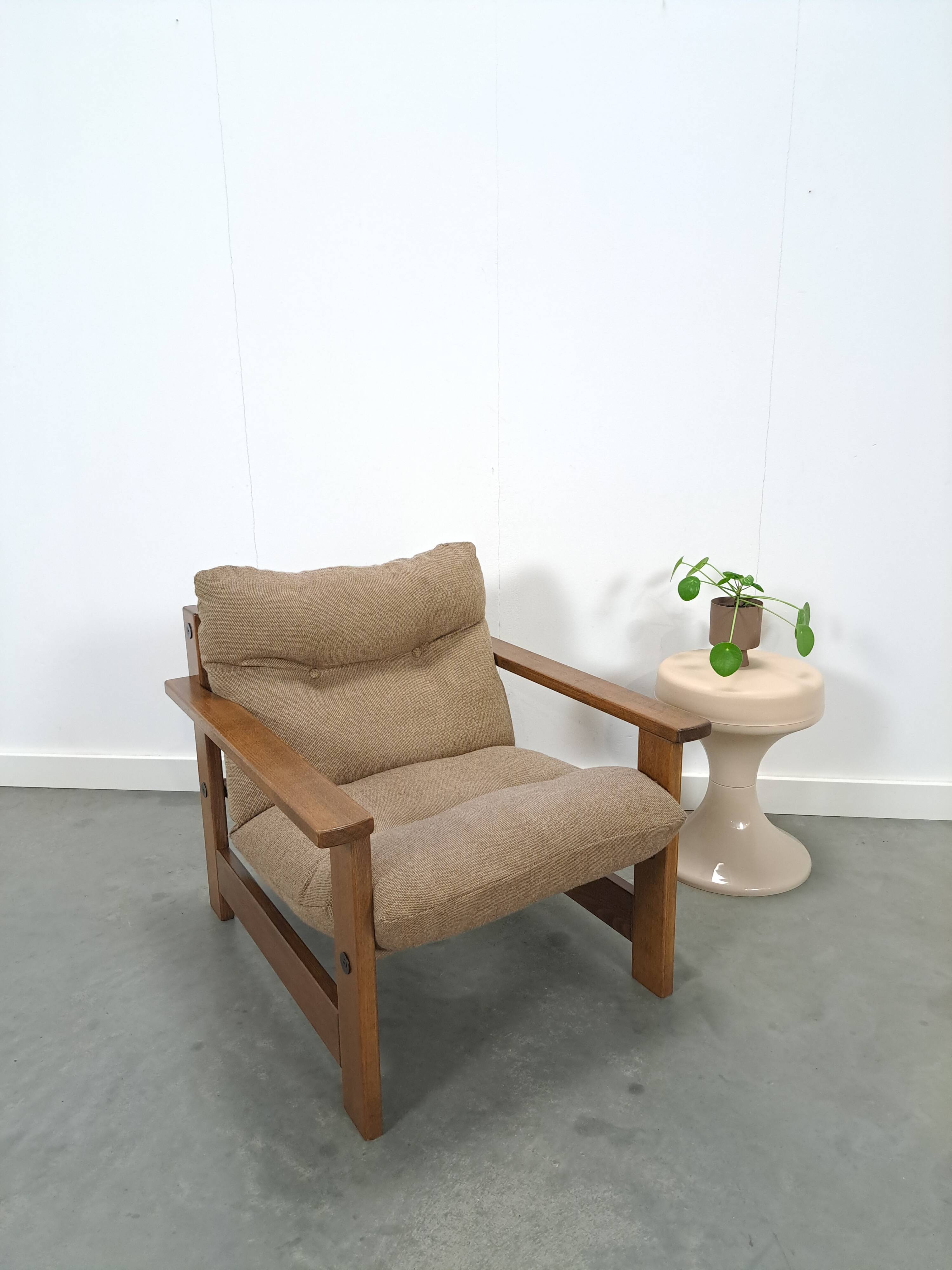 Brown-grey armchair with an oak frame.