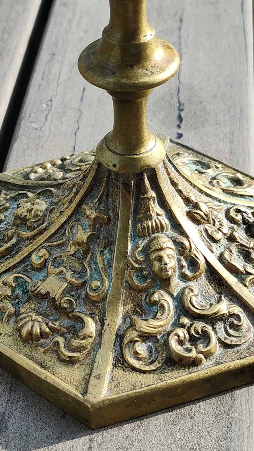 Baroque/Antique style torch candleholder, nineteenth, gilded bronze. Head motifs, volute arabesques