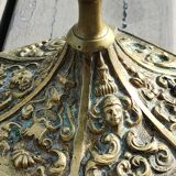 Baroque/Antique style torch candleholder, nineteenth, gilded bronze. Head motifs, volute arabesques