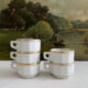 5 vintage porcelain bistro coffee cups from Paris with gold trim.