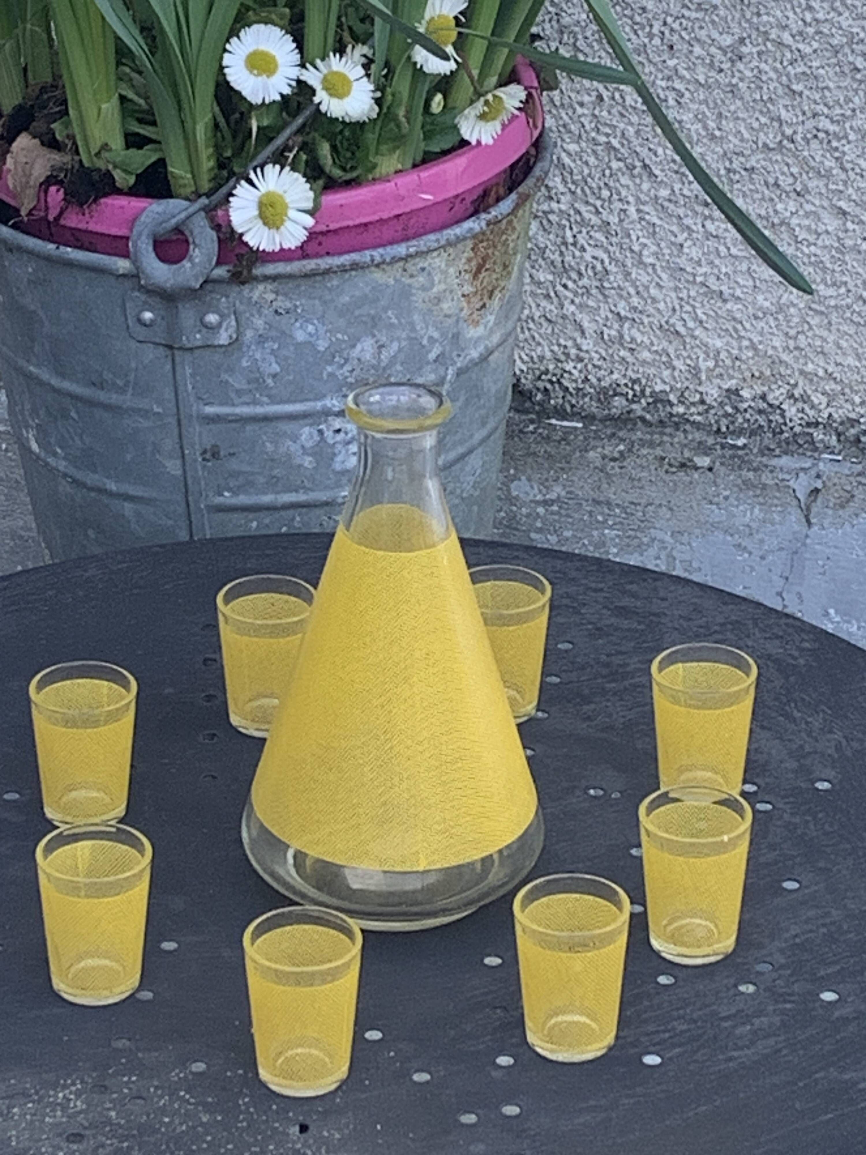 Liqueur service composed of a glass carafe and 8 small yellow screen-printed glasses