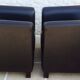 2 club armchairs with a chocolate faux leather seat and backrest and wooden legs.