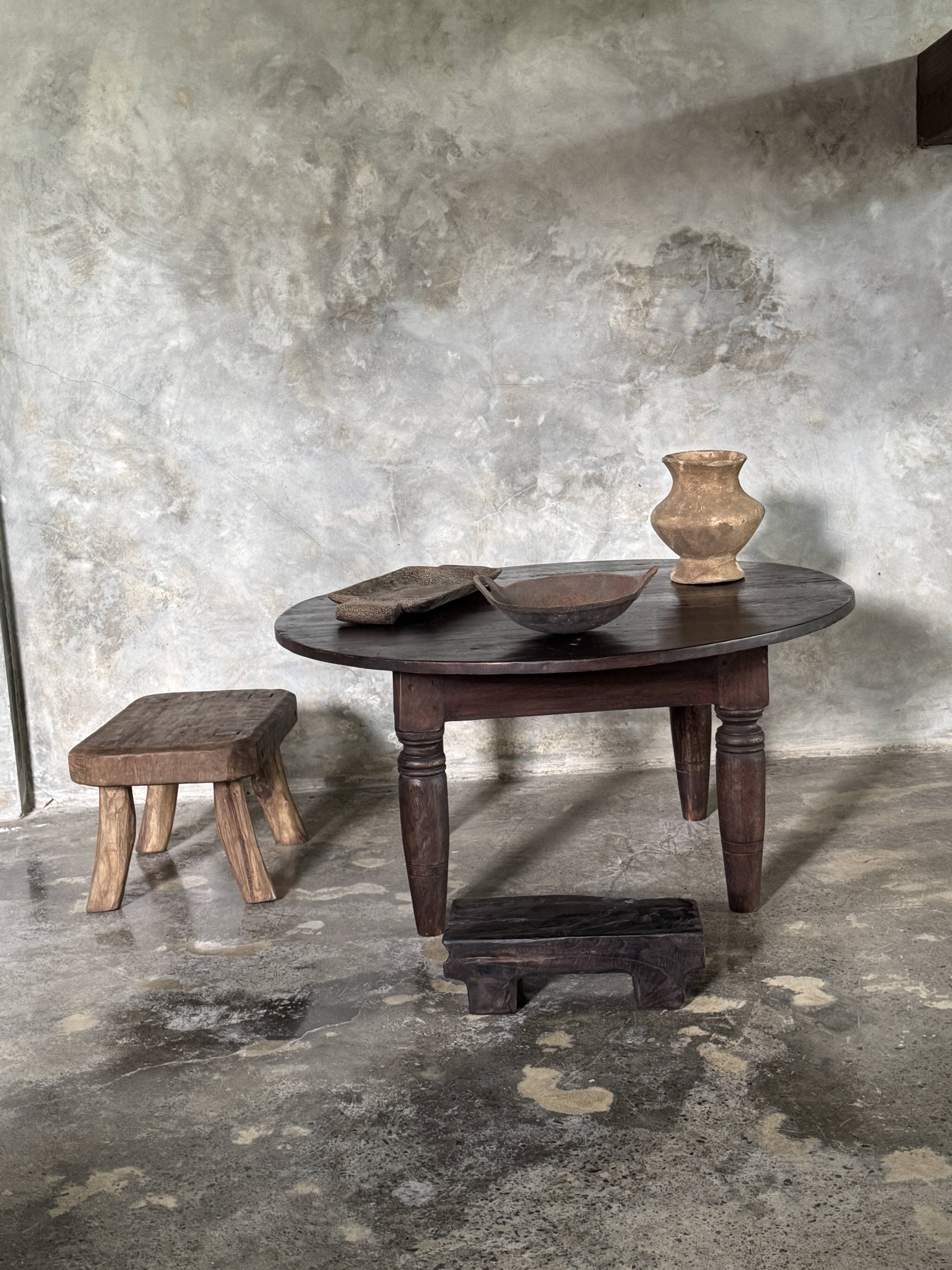 Antique round coffee table in Indonesian teak with turned legs.