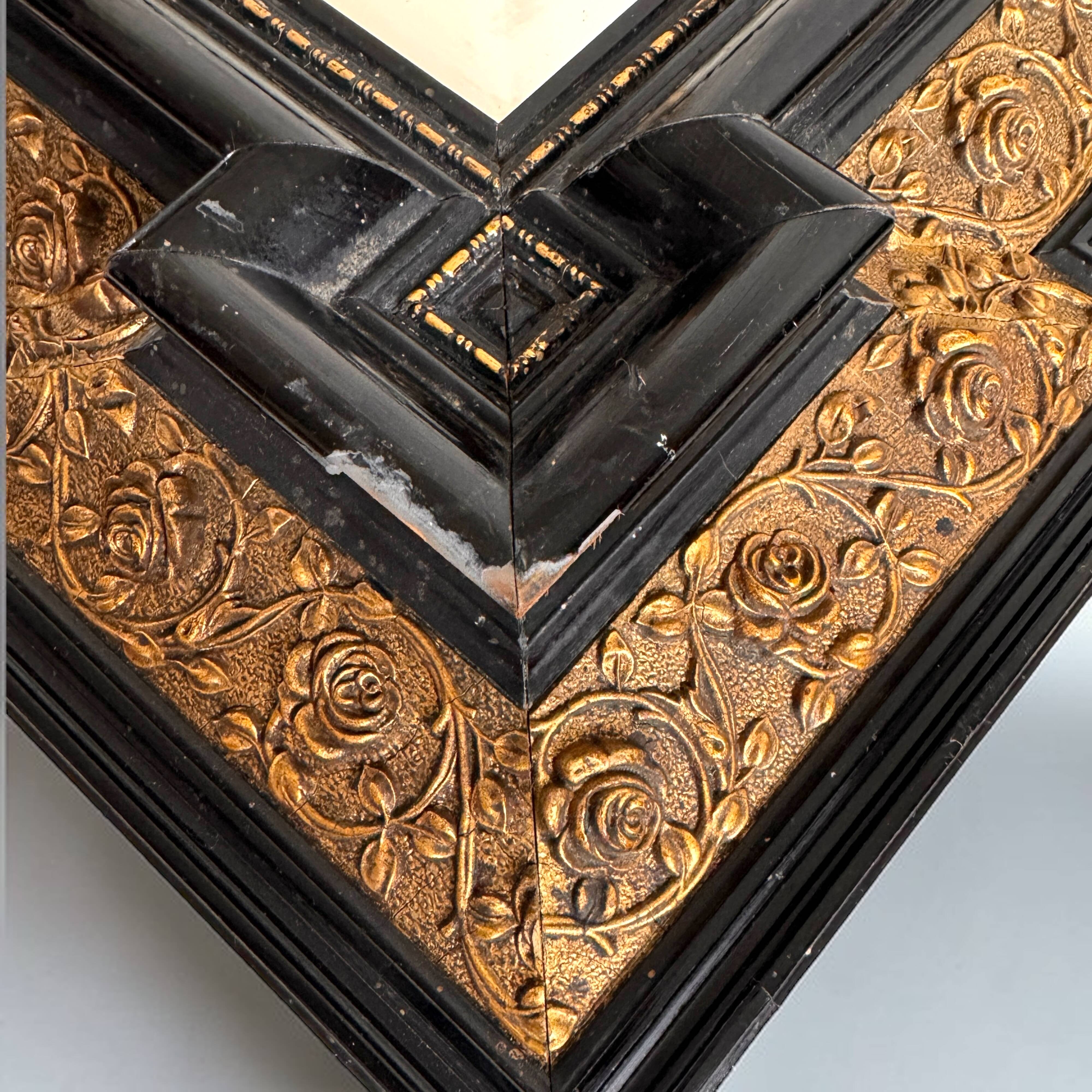 Antique wall mirror in blackened wood and gilded stucco, 19th-century Dutch style.
