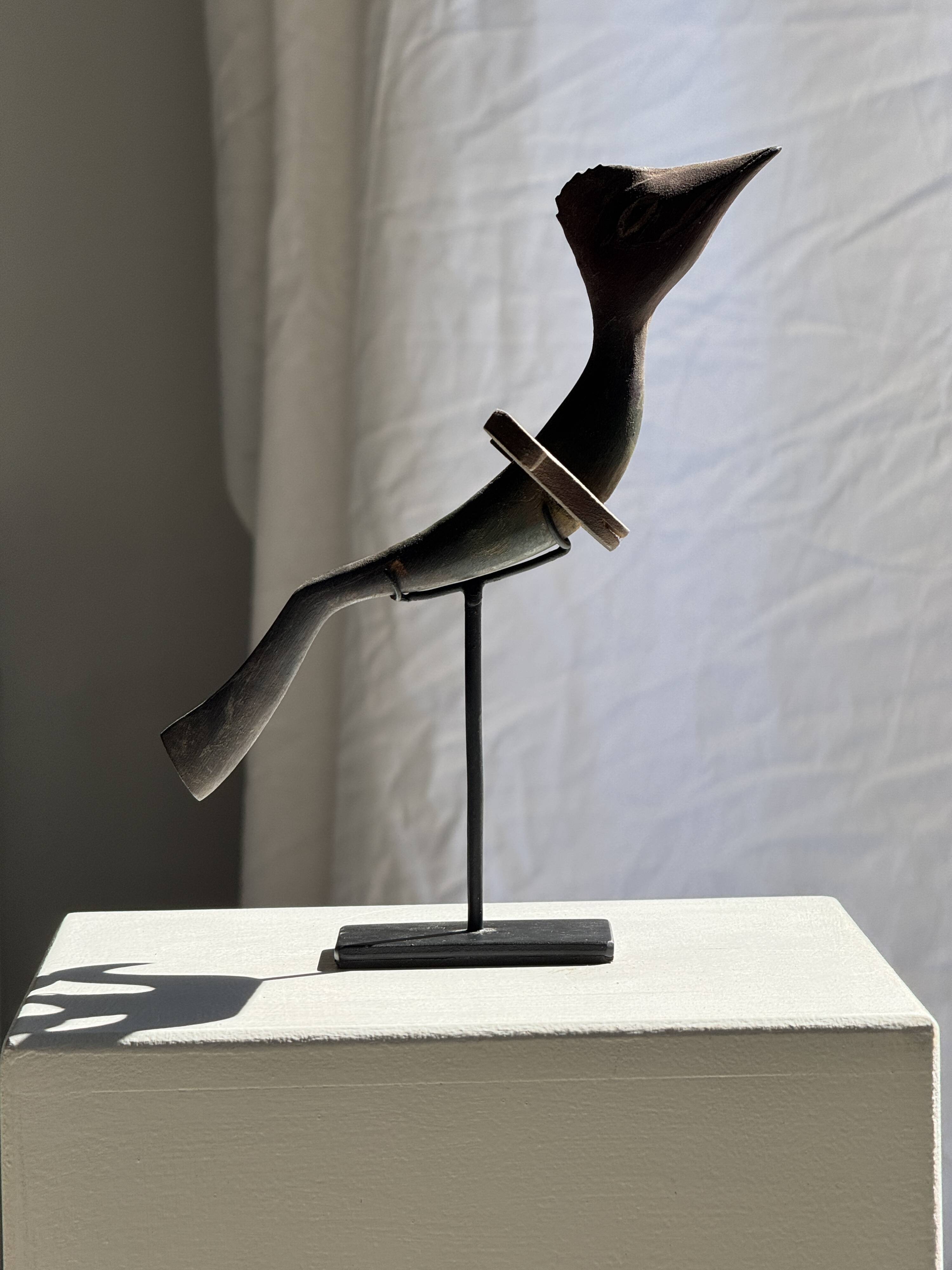 Traditional Indonesian decorative wooden bird on a base, crest model.