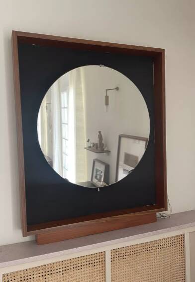 Scandinavian mirror with wooden frame and backlighting.