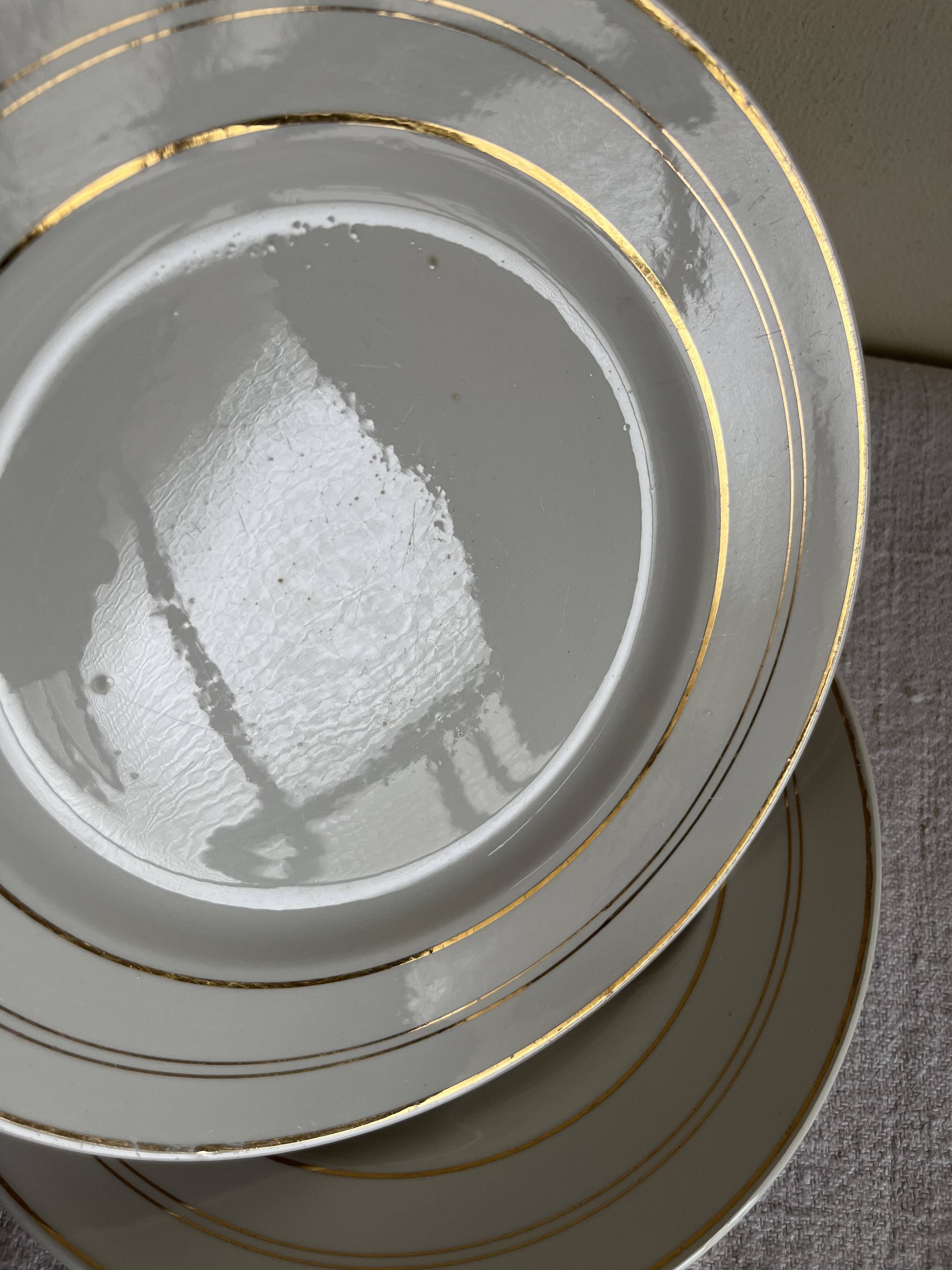 Set of 8 modernist flat plates in fine earthenware with pure gold trim, 1930.