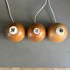 Three wooden ball-shaped lamp stands in light wood.