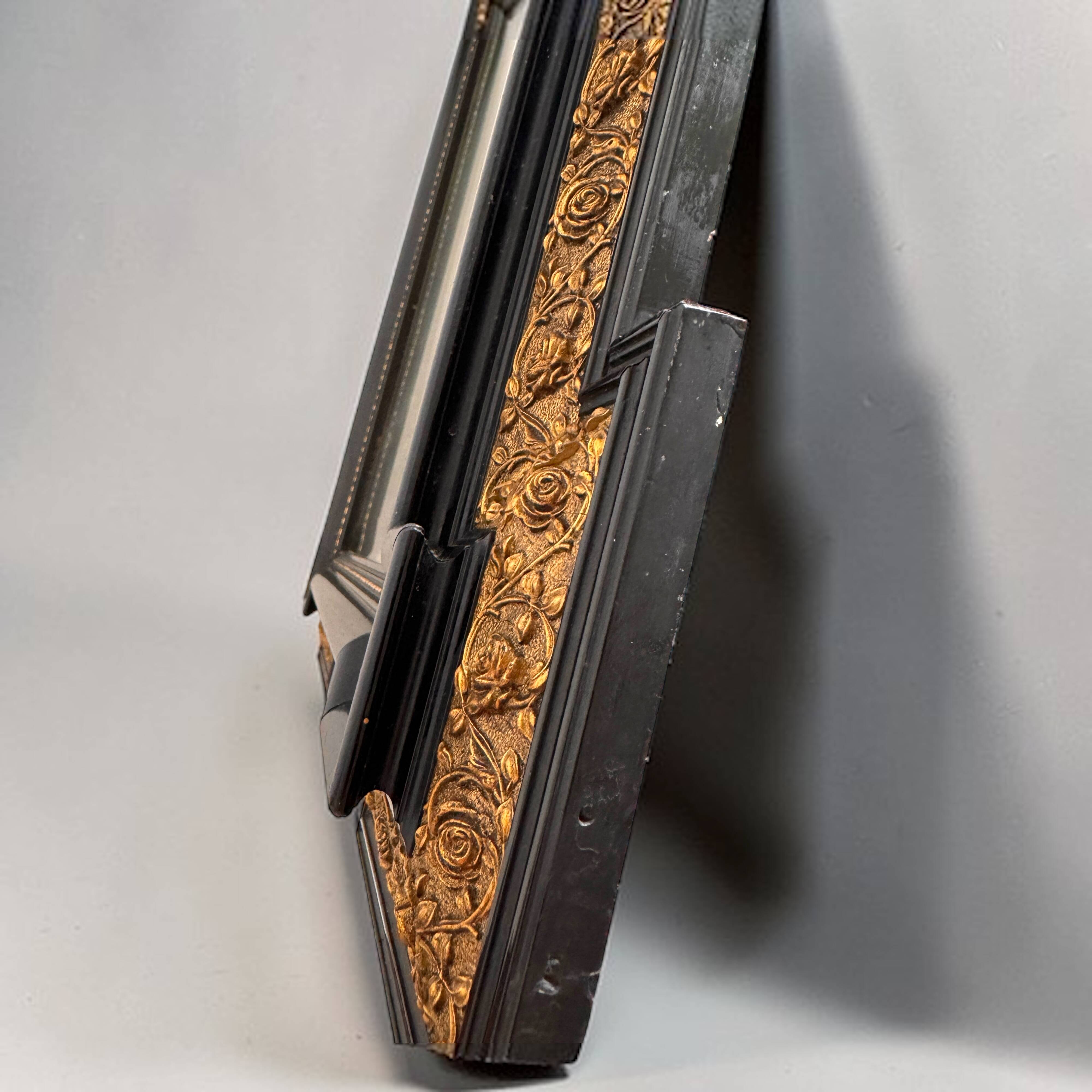 Antique wall mirror in blackened wood and gilded stucco, 19th-century Dutch style.