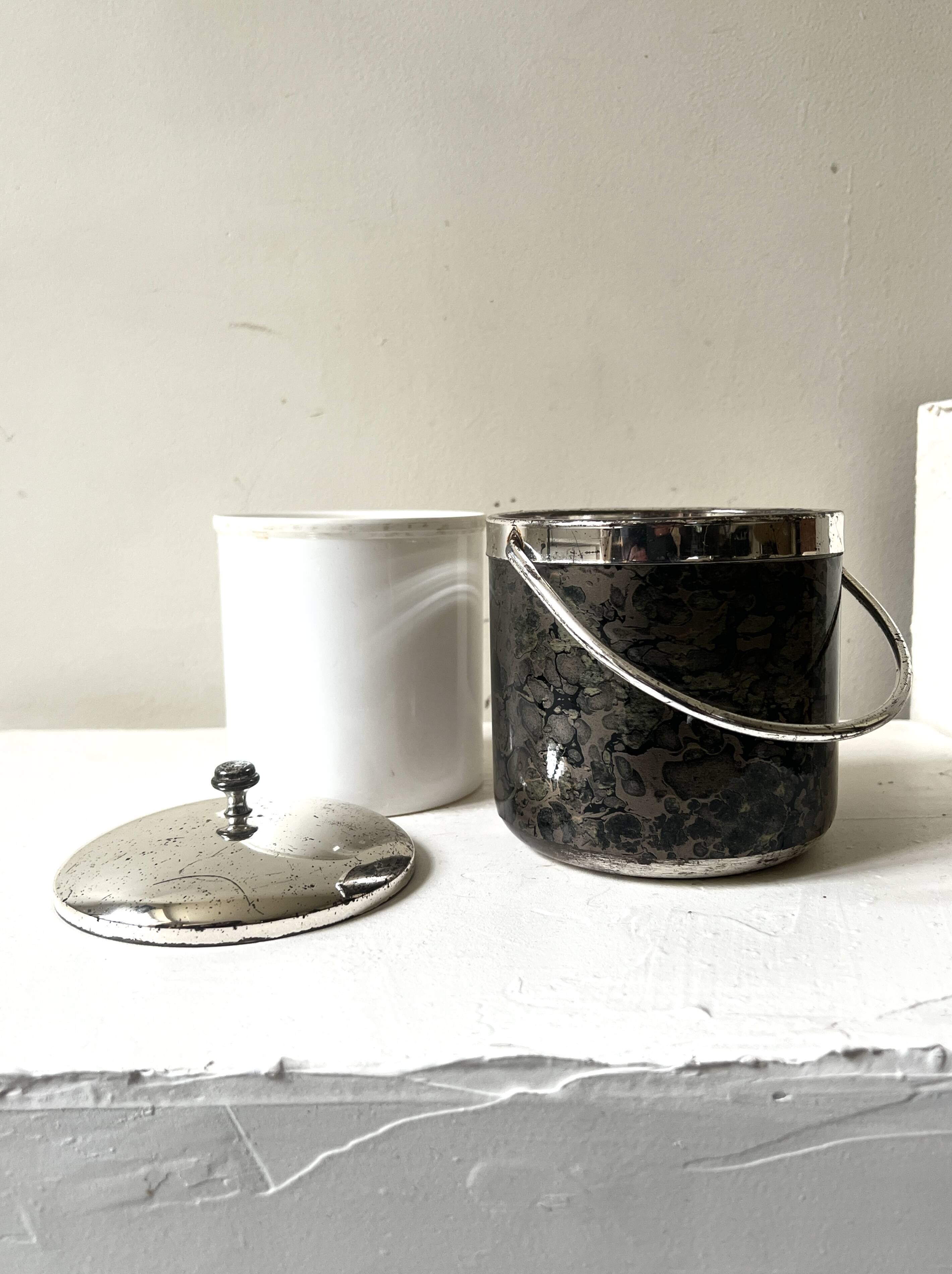 Vintage chrome metal ice bucket with black marbled design, 1970s style.
