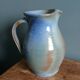 Enamel pitcher in pastel blue and green, signed