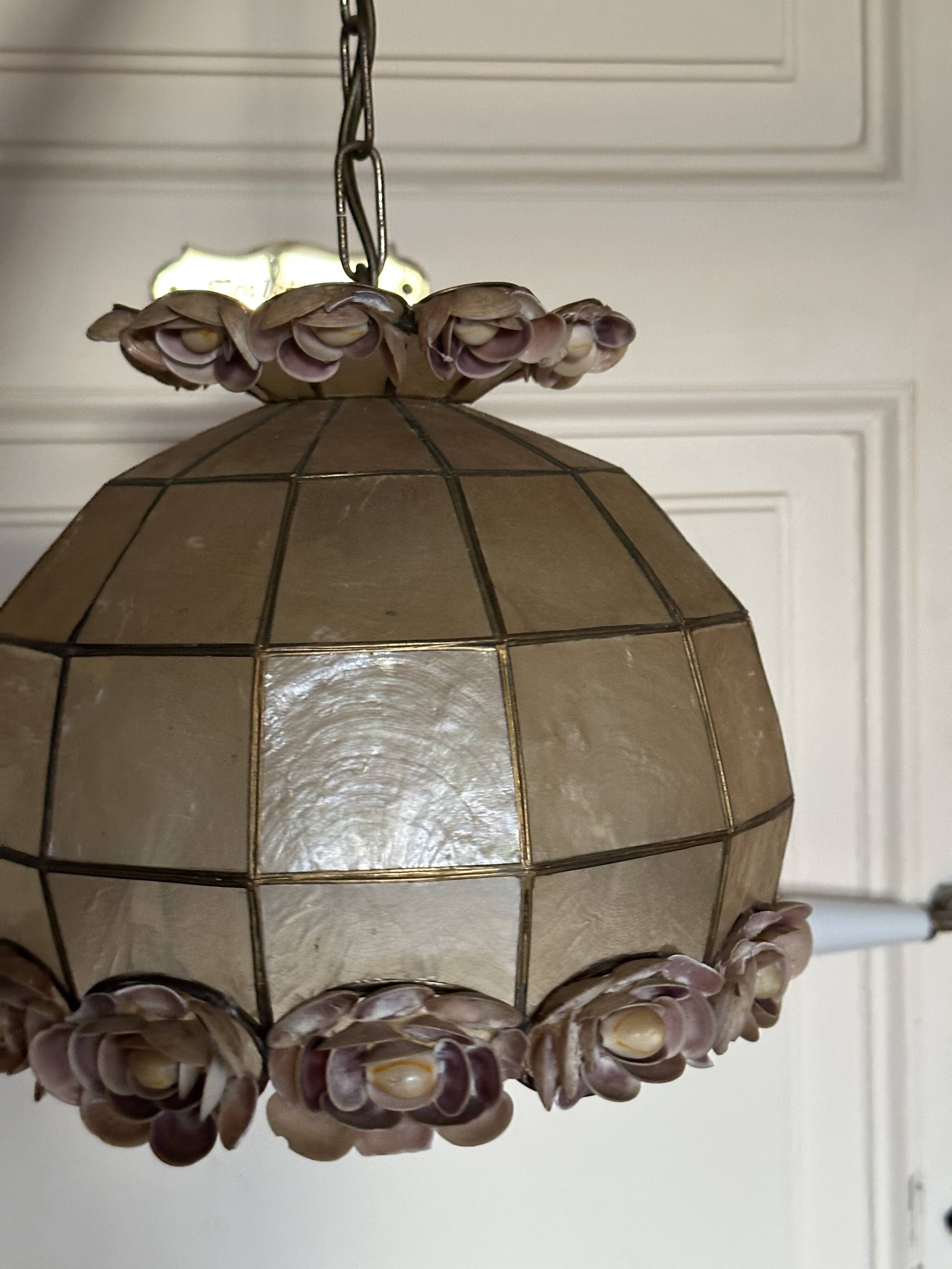 Vintage pendant light with a pearlescent shade and floral decoration.