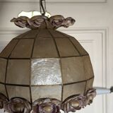 Vintage pendant light with a pearlescent shade and floral decoration.