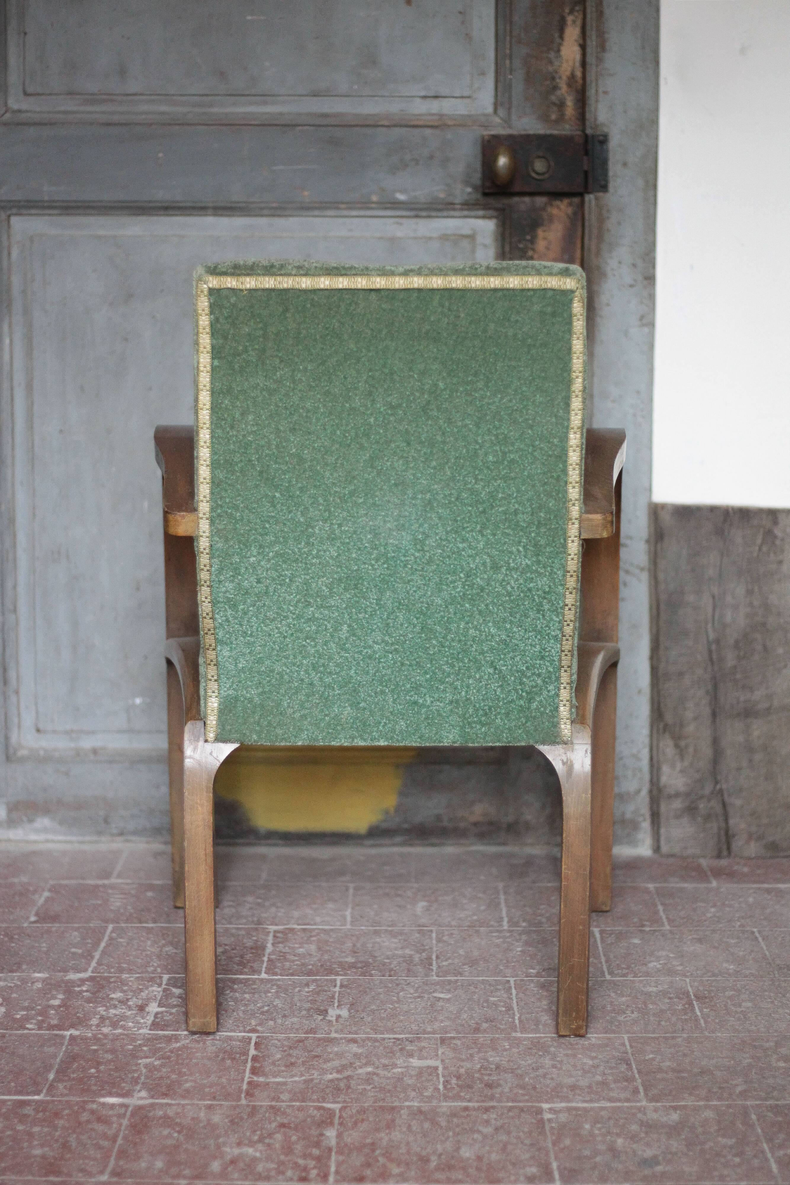 Art Deco armchair in wood and green fabric, living room armchair, interior decor.