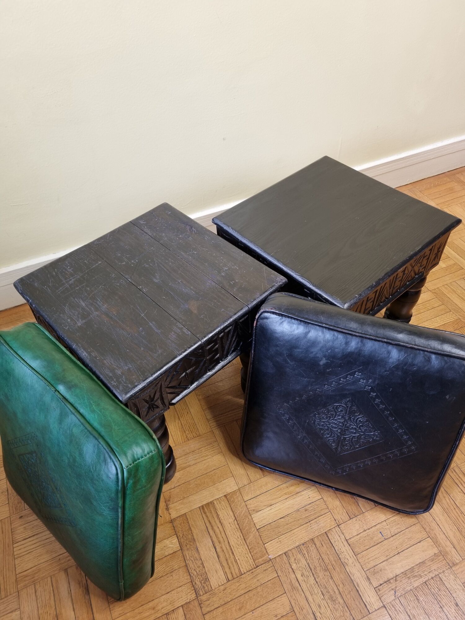 Pair of Moroccan poufs in stamped leather with a carved wooden base, Rabat