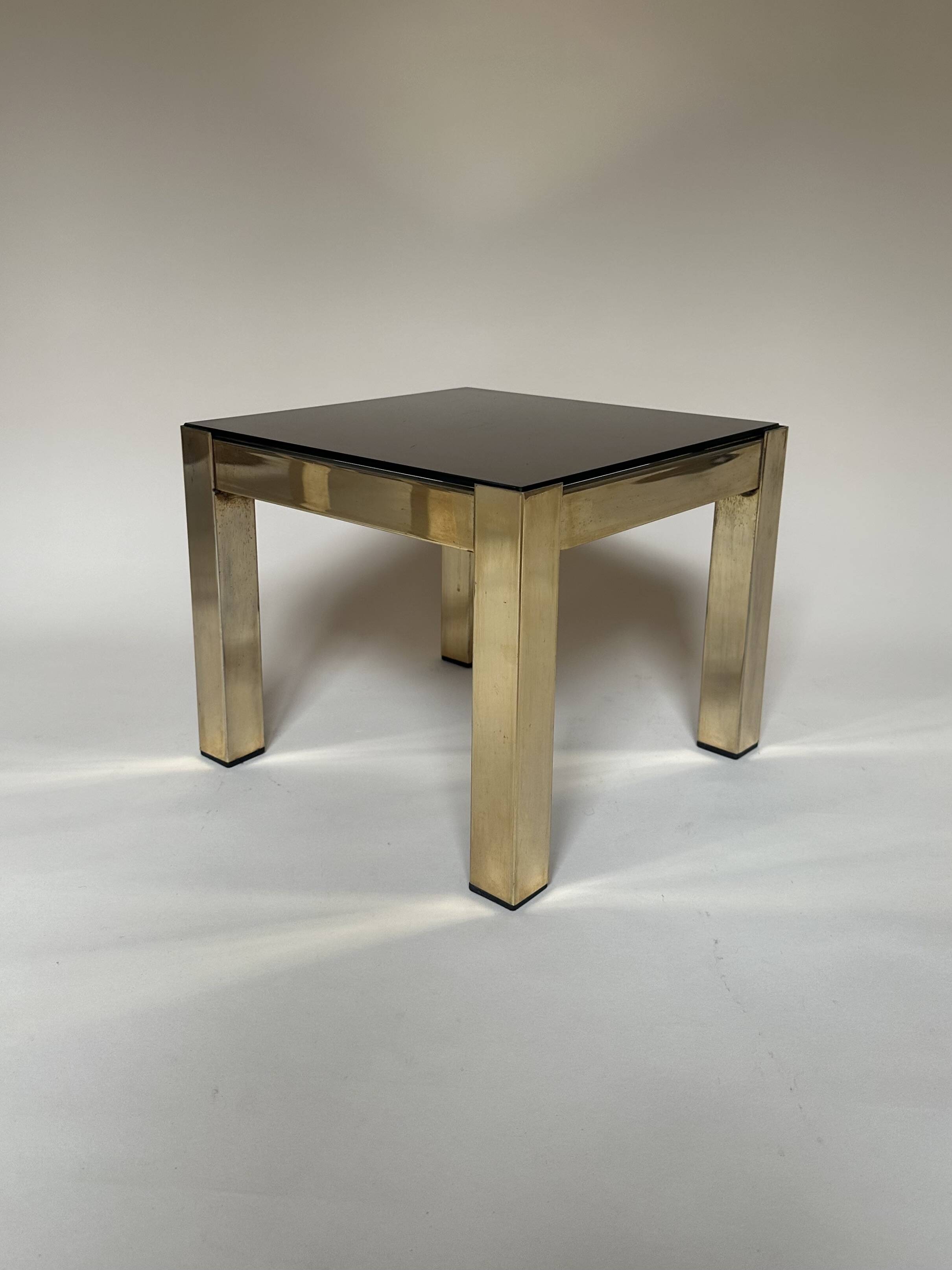 Set of three nesting side tables in brass and smoked mirror.