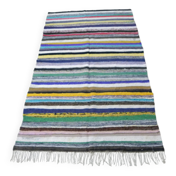 Vintage traditional nomadic kilim ethnic rug with multicoloured stripes.