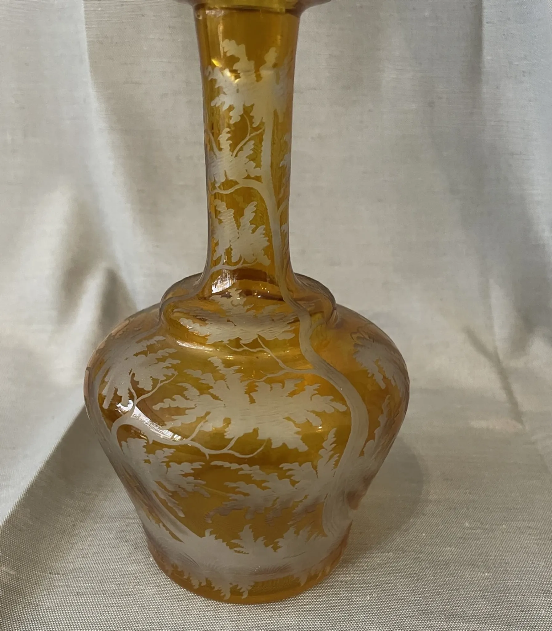 Amber bohemian glass liqueur carafe decorated with a stag in the forest.