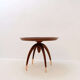 Round Art Deco side table in wood with curved legs and brass feet.
