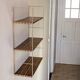 Golden wire shelf in metal with a wood effect.