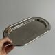 Small stainless steel tray with knot pattern.