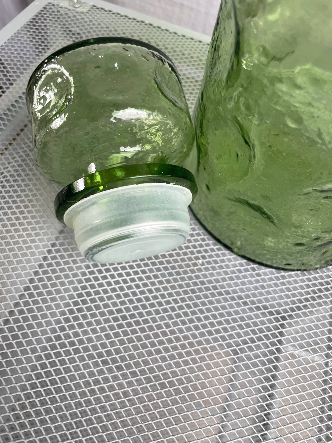 Green glass bottle with craters