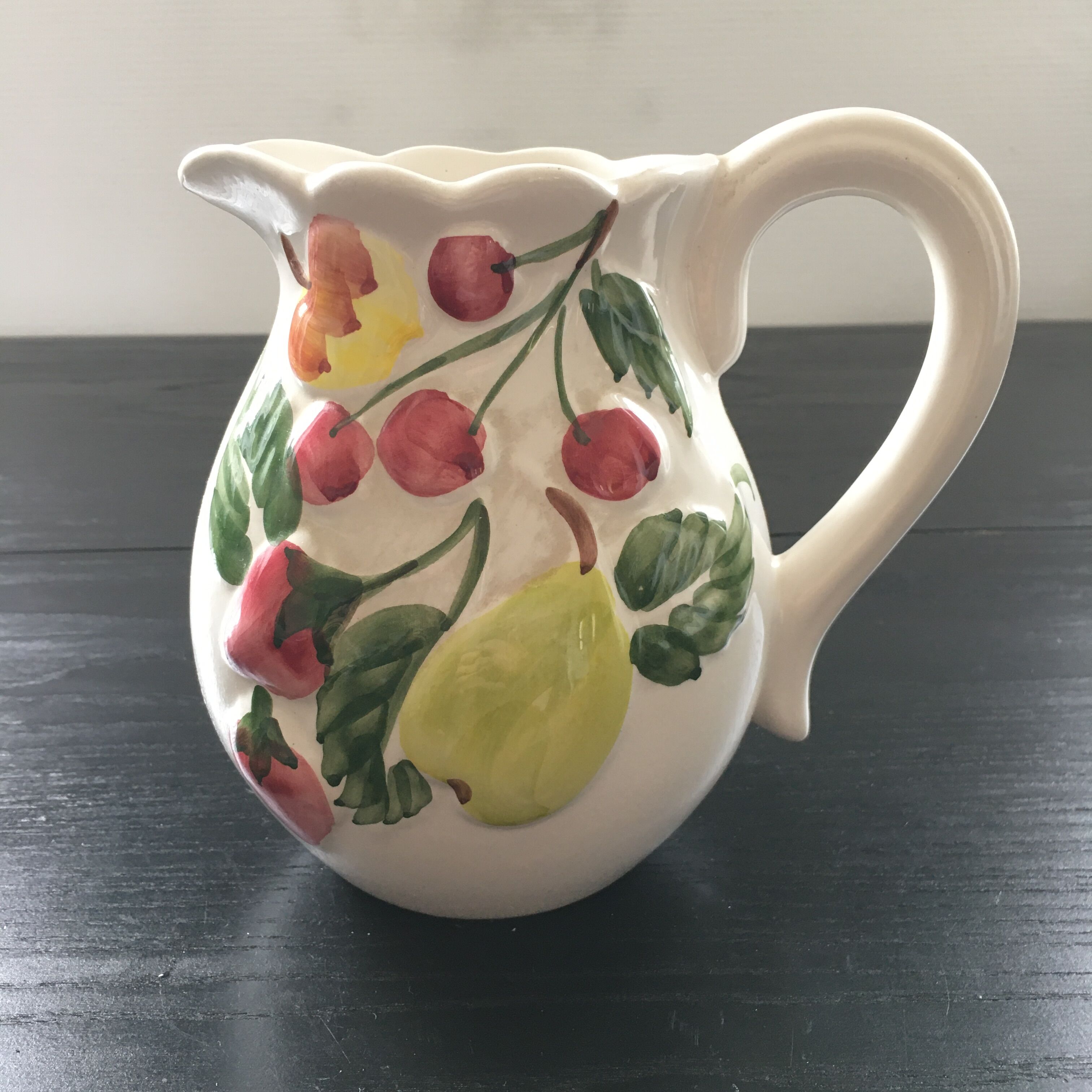 Fruit-decorated pitcher in slipware