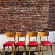 Set of 4 vintage bistro chairs in wood and red faux leather, with splayed legs.
