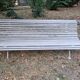 Pair of antique wooden slatted benches with wrought iron legs.