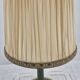 Brass table lamp with green patina and empire-style fabric shade.